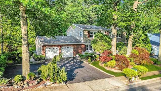 1 Algonquin Dr, Marlboro, NJ 07746 - view of front of home featuring an attached garage, asphalt driveway, brick siding, and a shingled roof