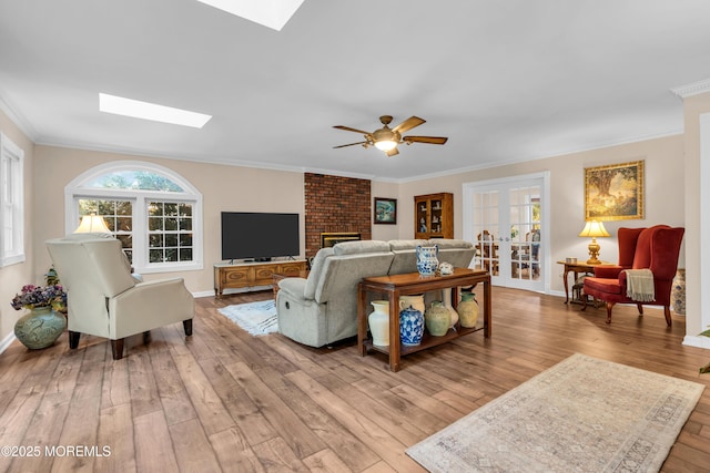 1 Algonquin Dr, Marlboro, NJ 07746 - living area featuring a skylight, hardwood / wood-style flooring, crown molding, ceiling fan, and french doors