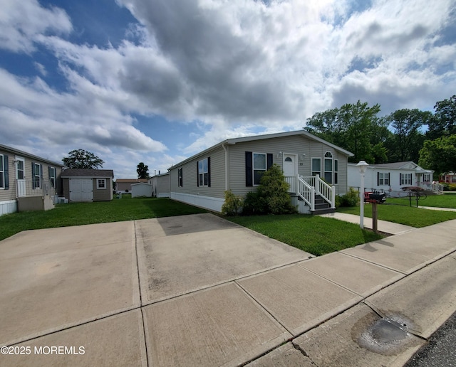 69 Robin Pl, Freehold, NJ 07728 - manufactured / mobile home with a storage unit, a front yard, and driveway