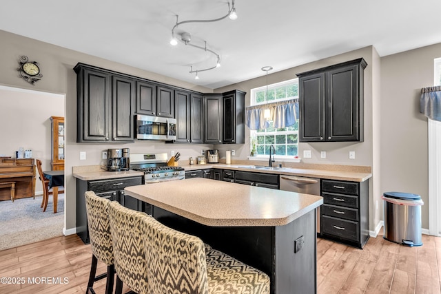 46 Timberline Rd, Bayville, NJ 08721 - kitchen with appliances with stainless steel finishes, light countertops, light wood finished floors, dark cabinets, and a center island