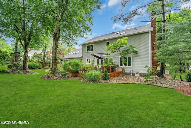 5 Leighton Dr, East Brunswick, NJ 08816 - back of house with a chimney, a deck, and a lawn