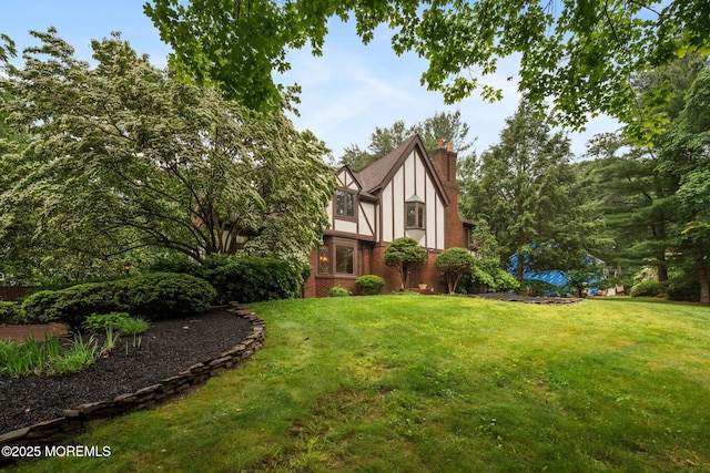 245 Borden Rd, Middletown, NJ 07748 - view of side of home with a chimney, a yard, brick siding, and stucco siding