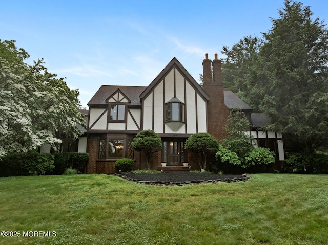 245 Borden Rd, Middletown, NJ 07748 - tudor-style house with a front lawn, a chimney, and stucco siding