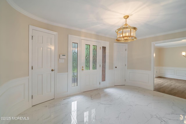 245 Borden Rd, Middletown, NJ 07748 - entrance foyer with a chandelier, a decorative wall, wainscoting, marble finish flooring, and ornamental molding