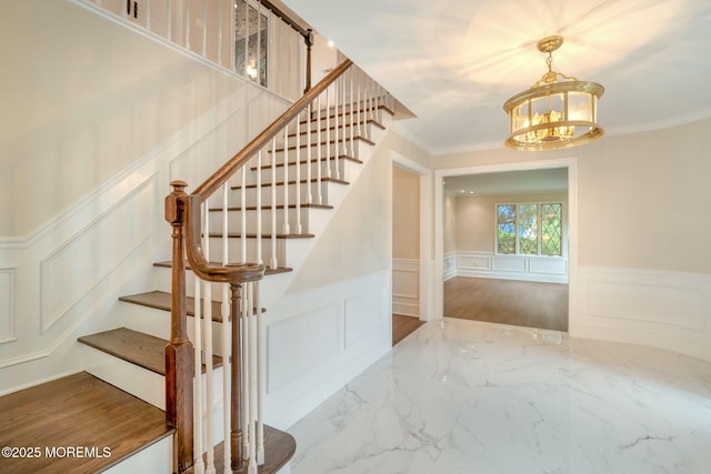 245 Borden Rd, Middletown, NJ 07748 - stairs with a decorative wall, a chandelier, marble finish floors, a wainscoted wall, and ornamental molding