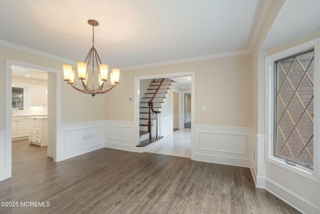 245 Borden Rd, Middletown, NJ 07748 - unfurnished dining area featuring stairway, a chandelier, wood finished floors, crown molding, and a wainscoted wall