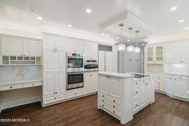 245 Borden Rd, Middletown, NJ 07748 - kitchen with stainless steel double oven, ornamental molding, a raised ceiling, a kitchen island, and dark wood-style flooring