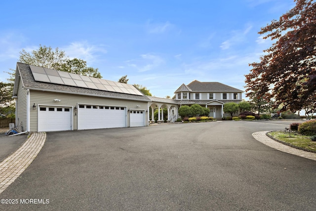 1413 Gully Rd, Wall, NJ 07719 - view of front of property featuring roof mounted solar panels, asphalt driveway, and an attached garage