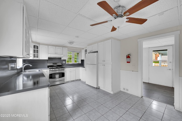105 Cedar Grove Rd, Toms River, NJ 08753 - kitchen featuring gas range, freestanding refrigerator, under cabinet range hood, dark countertops, and white cabinets