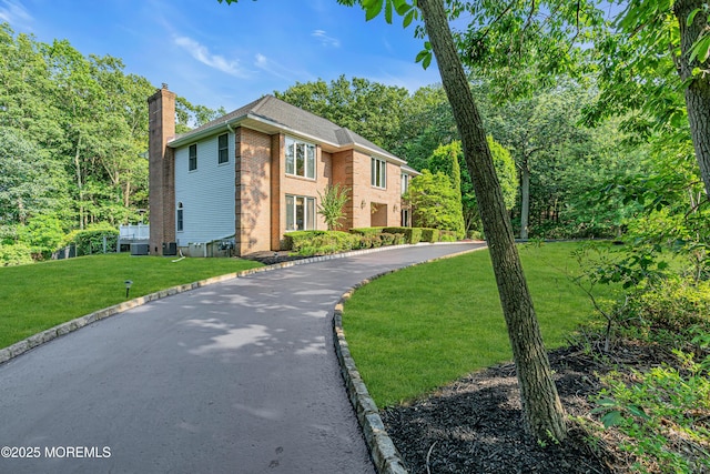 10 Cheryl Ln, Millstone, NJ 08510 - view of front of house with a chimney, brick siding, a front lawn, and driveway