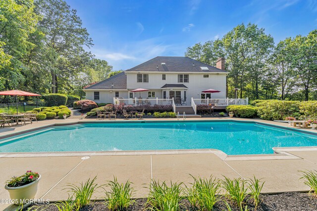 10 Cheryl Ln, Millstone, NJ 08510 - outdoor pool featuring a wooden deck, view of scattered trees, and a patio area