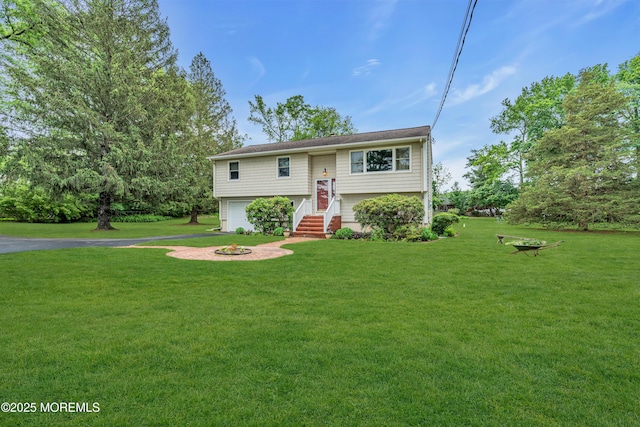 136 Iron Ore Rd, Manalapan, NJ 07726 - bi-level home featuring a front yard, an outdoor fire pit, driveway, and an attached garage