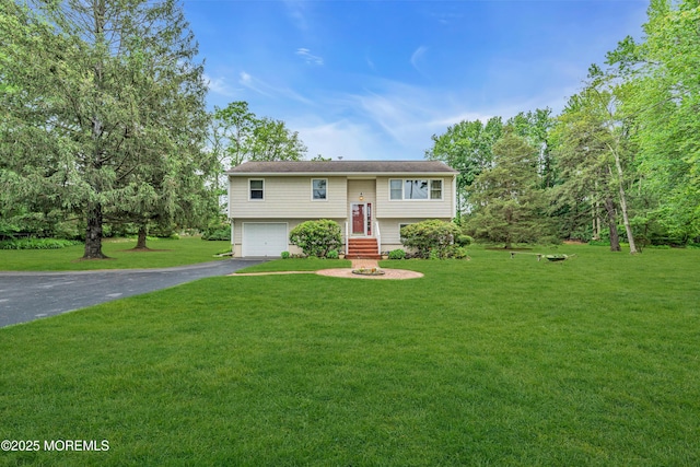136 Iron Ore Rd, Manalapan, NJ 07726 - bi-level home featuring asphalt driveway, a front yard, and a garage