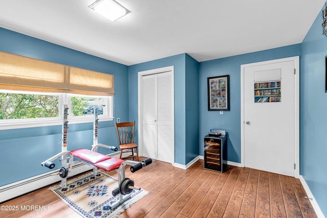 136 Iron Ore Rd, Manalapan, NJ 07726 - workout area with wood finished floors, beverage cooler, and a baseboard radiator