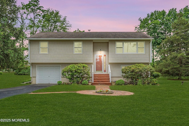 136 Iron Ore Rd, Manalapan, NJ 07726 - bi-level home with asphalt driveway, a lawn, a garage, and roof with shingles