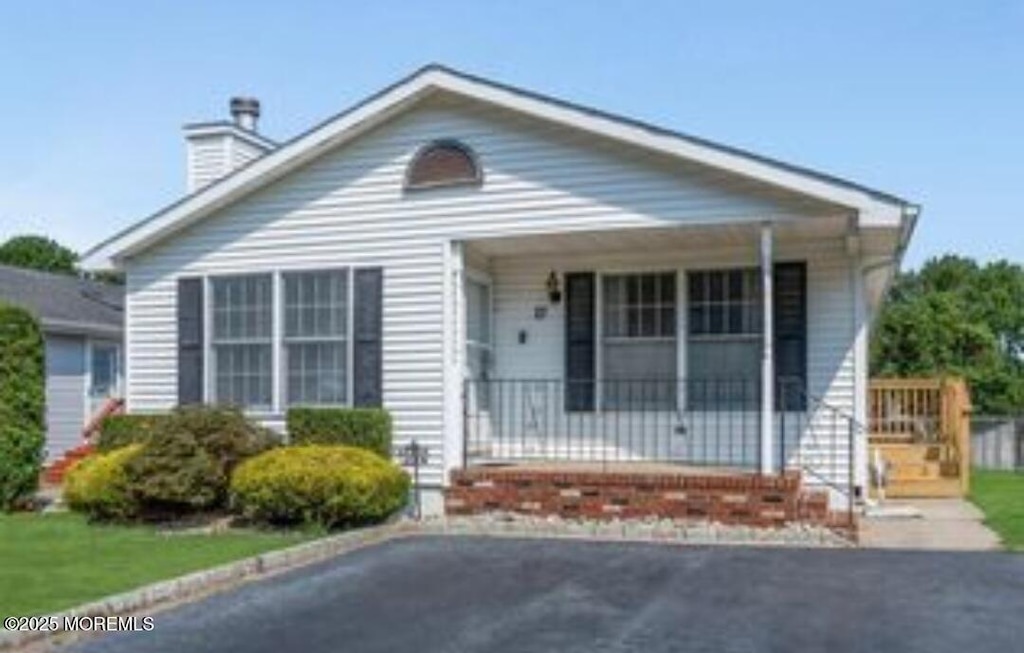 21 Parkview Way, Manalapan, NJ 07726 - bungalow-style house featuring a porch and a chimney