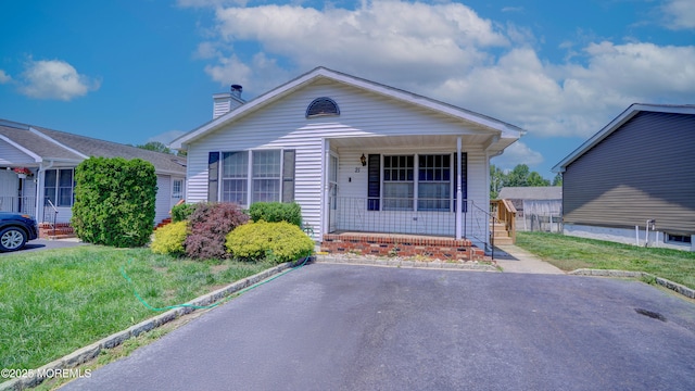 21 Parkview Way, Manalapan, NJ 07726 - view of front of house with covered porch, a chimney, and a front lawn