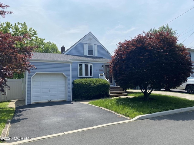184 Washington Ave, Matawan, NJ 07747 - view of front of home featuring a garage, roof with shingles, a chimney, and asphalt driveway