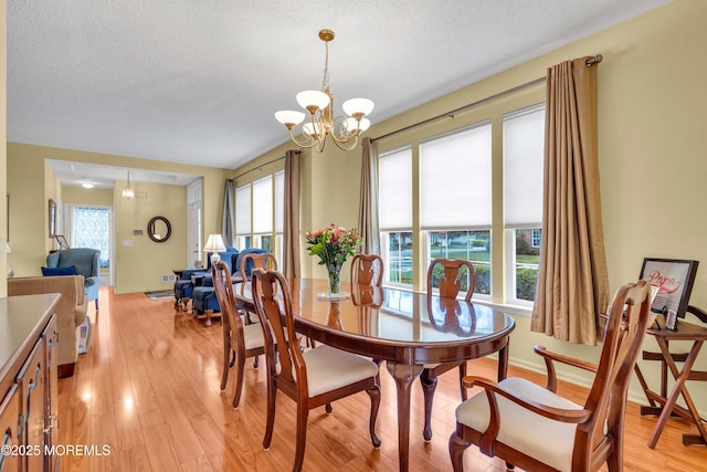 143 Sylvan Lake Blvd, Bayville, NJ 08721 - dining space with light wood-type flooring, a chandelier, and a textured ceiling