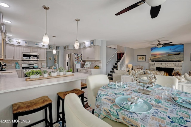 728 Drum Point Rd, Brick, NJ 08723 - dining room with ceiling fan, stairs, and a stone fireplace