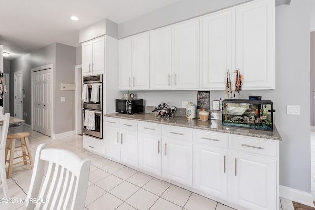 14 Tuscan Dr, Freehold, NJ 07728 - kitchen featuring stainless steel double oven, black microwave, stone counters, white cabinets, and light tile patterned floors