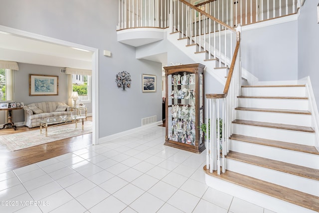 14 Tuscan Dr, Freehold, NJ 07728 - stairs with a high ceiling, healthy amount of natural light, tile patterned flooring, and baseboards
