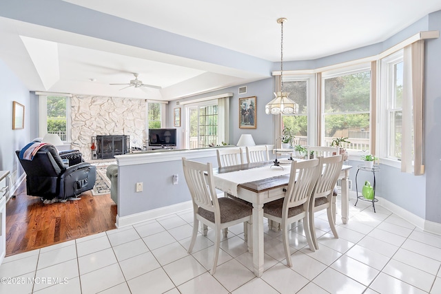 14 Tuscan Dr, Freehold, NJ 07728 - dining space with light tile patterned floors, a fireplace, baseboards, and a tray ceiling