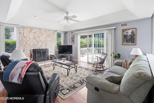 14 Tuscan Dr, Freehold, NJ 07728 - living room featuring a raised ceiling, a ceiling fan, wood finished floors, and a stone fireplace