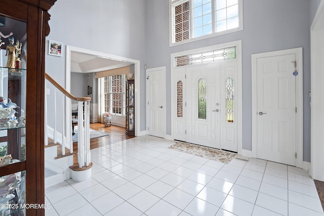 14 Tuscan Dr, Freehold, NJ 07728 - foyer with a towering ceiling, stairway, light tile patterned flooring, and baseboards