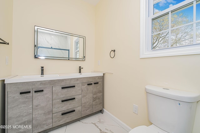 147 Old Bridge Tpke, East Brunswick, NJ 08816 - bathroom featuring marble look tiles, double vanity, baseboards, and toilet