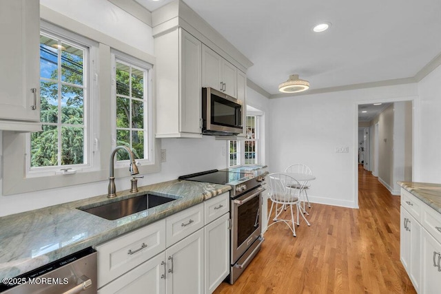 708 Schoolhouse Rd, Brielle, NJ 08730 - kitchen with stainless steel appliances, light stone counters, white cabinetry, light wood finished floors, and recessed lighting