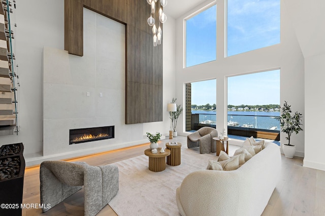 4 Boat Club Ct Unit 3E, Red Bank, NJ 07701 - living room with light wood-type flooring, a tile fireplace, a high ceiling, and a water view