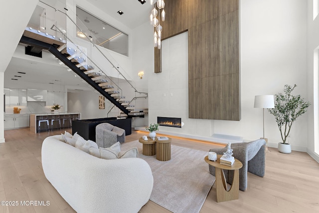 4 Boat Club Ct Unit 3E, Red Bank, NJ 07701 - living area featuring a high ceiling, light wood finished floors, a fireplace, and stairway
