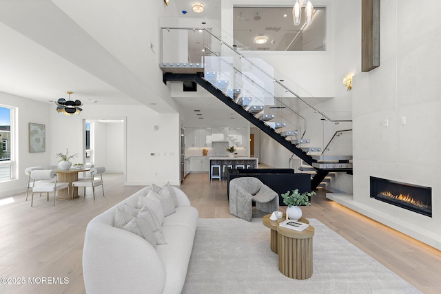 4 Boat Club Ct Unit 3E, Red Bank, NJ 07701 - living area featuring stairs, a towering ceiling, wood finished floors, and a tiled fireplace