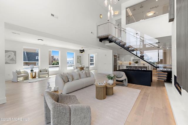 4 Boat Club Ct Unit 3E, Red Bank, NJ 07701 - living room featuring a towering ceiling, wood-type flooring, and stairs