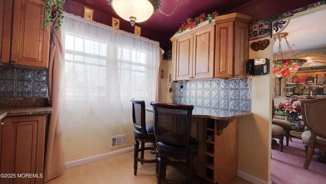 277 Grandview Ave, Piscataway Twp, NJ 08854 - kitchen with baseboards, backsplash, light wood-type flooring, and brown cabinets