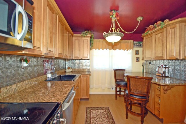 277 Grandview Ave, Piscataway Twp, NJ 08854 - kitchen with stainless steel appliances, a sink, light wood-style floors, backsplash, and stone counters