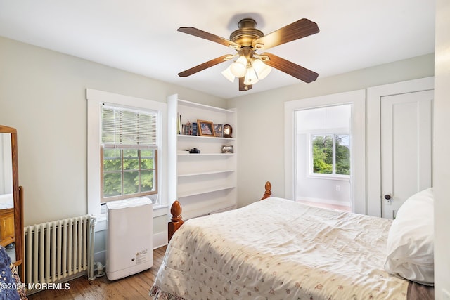 699 River Rd, Fair Haven, NJ 07704 - bedroom with radiator, multiple windows, wood finished floors, and ceiling fan