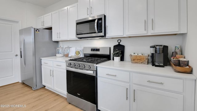 17 Chapman Ave, Neptune Township, NJ 07753 - kitchen featuring appliances with stainless steel finishes, white cabinetry, light wood-type flooring, and light stone countertops