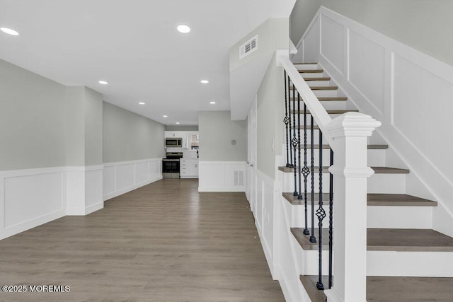 84 Briar Mills Dr, Brick, NJ 08724 - staircase with wood finished floors, wainscoting, a decorative wall, and recessed lighting