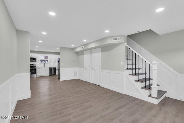 84 Briar Mills Dr, Brick, NJ 08724 - unfurnished living room with a decorative wall, a wainscoted wall, wood finished floors, recessed lighting, and stairs