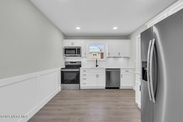 84 Briar Mills Dr, Brick, NJ 08724 - kitchen with appliances with stainless steel finishes, a sink, white cabinetry, backsplash, and light countertops