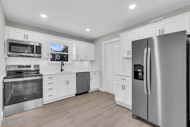 84 Briar Mills Dr, Brick, NJ 08724 - kitchen featuring appliances with stainless steel finishes, a sink, light countertops, white cabinetry, and recessed lighting
