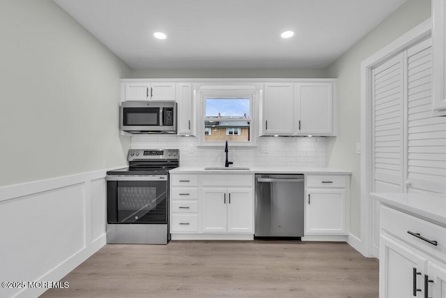 84 Briar Mills Dr, Brick, NJ 08724 - kitchen featuring stainless steel appliances, a sink, white cabinets, backsplash, and light countertops