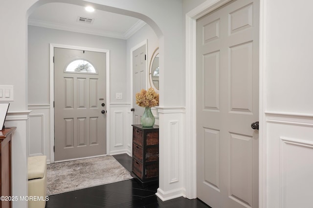 8 Clement Ln, Leonardo, NJ 07737 - foyer entrance featuring a decorative wall, crown molding, arched walkways, dark wood finished floors, and wainscoting