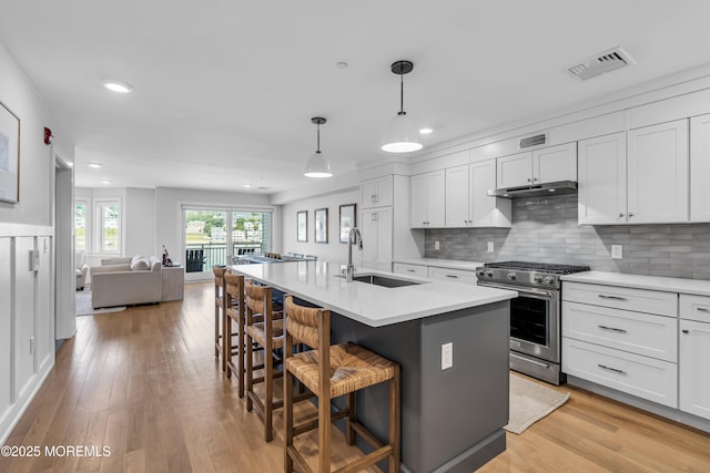 150 Ocean Ave Unit 6, Sea Bright, NJ 07760 - kitchen with stainless steel range with gas cooktop, under cabinet range hood, open floor plan, recessed lighting, and light countertops
