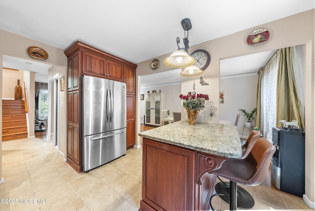35 Lone Star Ln, Manalapan, NJ 07726 - kitchen with freestanding refrigerator, a breakfast bar area, light stone countertops, hanging light fixtures, and light tile patterned flooring
