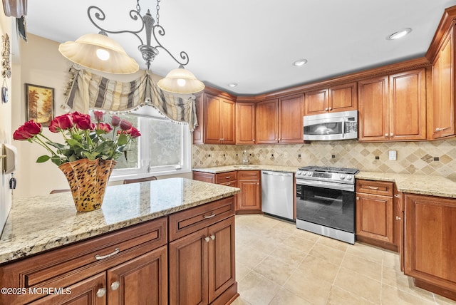 35 Lone Star Ln, Manalapan, NJ 07726 - kitchen featuring appliances with stainless steel finishes, a sink, brown cabinets, light stone counters, and tasteful backsplash