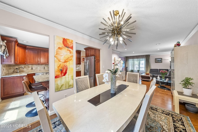 35 Lone Star Ln, Manalapan, NJ 07726 - dining area with a chandelier, ornamental molding, light wood-style flooring, and a textured ceiling