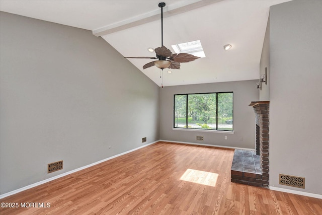 19 Northwoods Rd, Ocean Twp, NJ 07712 - unfurnished living room with a ceiling fan, light wood finished floors, beam ceiling, a skylight, and a fireplace
